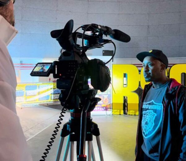 Randy Telg staat voor een camera tijdens een interview, symbool voor leiderschap en inspirerend verhalen delen